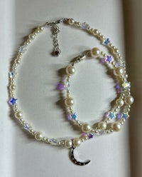 a necklace with pearls, crystals and a crescent