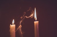 two candles with smoke coming out of them