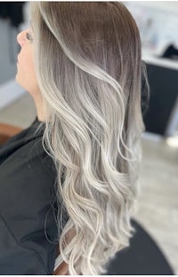 a woman's hair in a salon with grey and white ombre