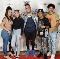 a group of people posing for a photo on a red carpet