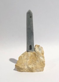 a piece of rock with a piece of metal sticking out of it