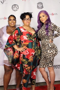 three women posing for a photo on a red carpet