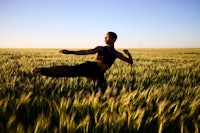 a woman doing karate in a wheat field