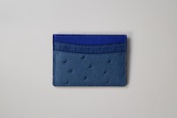 a blue card holder on a white surface