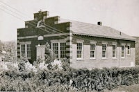an old black and white photo of a brick building