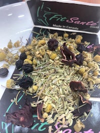 a bag of dried herbs and flowers on top of a white plate