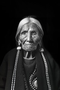 a black and white photo of an old native woman
