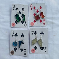 a set of playing cards with earrings on them