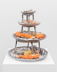 a three tier sculpture of seafood on a pedestal