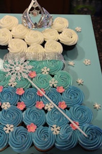 a frozen cupcake cake with a tiara on it