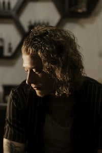 a man with long curly hair sitting at a table