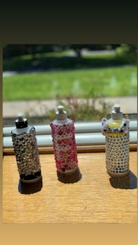 three small bottles sitting on a table next to a window