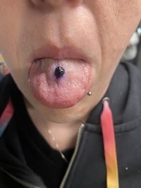 a woman with a purple piercing on her tongue
