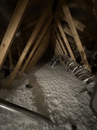 an attic with a lot of insulation and pipes