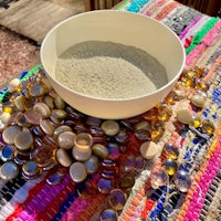 a bowl of sand and beads on a table