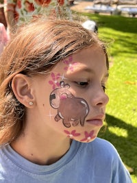 a girl with a face painted with a teddy bear