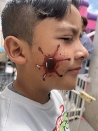 a boy with blood splattered on his face