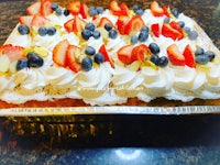 a cake with berries and whipped cream on top