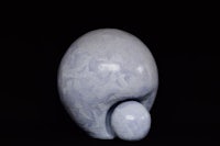 a sculpture of a blue egg on a black background