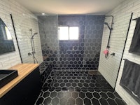 a black and white tiled bathroom with a shower