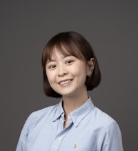 asian woman in a blue shirt posing for a photo
