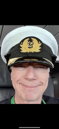 a man in a captain's hat is smiling