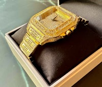 a gold watch with diamonds sitting in a box