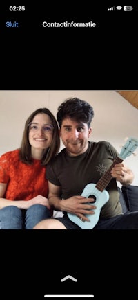 a man and woman are posing for a photo with an ukulele