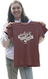 a woman holding up a maroon t - shirt that says i love wine