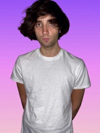 a young man in a white t - shirt standing in front of a purple background