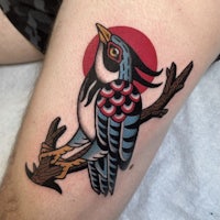 a tattoo of a bird sitting on a branch