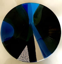 a blue and black glass plate on a white surface