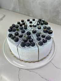 a cake with blueberries on top of a white plate