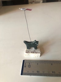 a small figurine of a dog next to a ruler