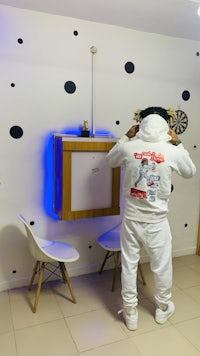 a man standing in a room with polka dots on the wall