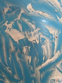 a close up of a blue and white marbled ball