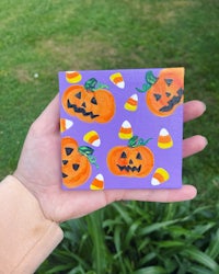 a person is holding a purple card with jack o lanterns on it
