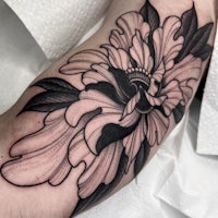 a black and white flower tattoo on the arm