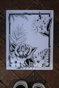 a black and white drawing of a flower and a pair of shoes