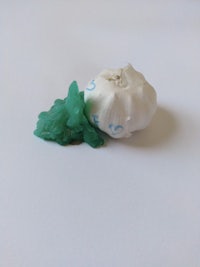 an image of a green and white garlic on a white surface