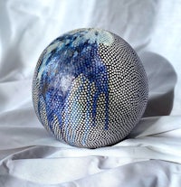 a blue and white ball on a white surface