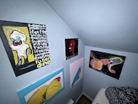 a room with several paintings on the wall