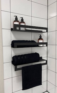 a black towel rack in a bathroom with towels on it
