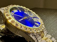a blue and gold watch with diamonds on it