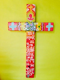 a colorful cross with words written on it