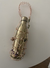 a gold bottle with a wire wrapped around it