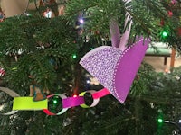 a christmas tree decorated with purple and pink paper ornaments