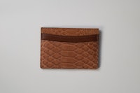 a tan python wallet on a white background
