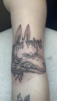 a tattoo of a wolf on a person's arm