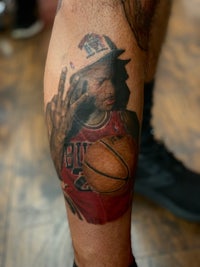 a tattoo of a man with a basketball on his leg